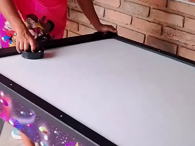 Mesa de air hockey branca com laterais estampadas de galáxia