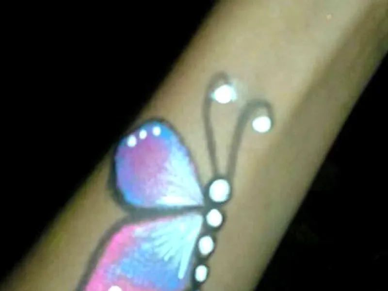 Borboleta colorida pintada no braço